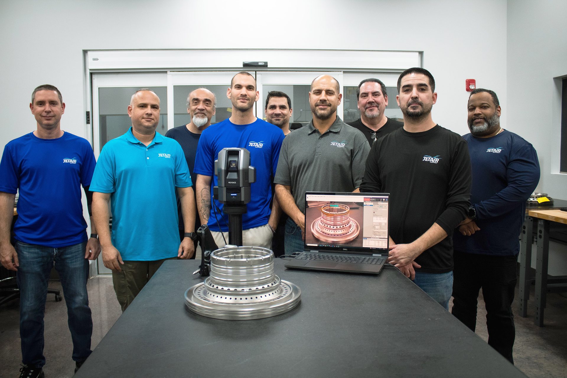 JET AIR team with a 3D scanner, laptop, and an aerospace component.