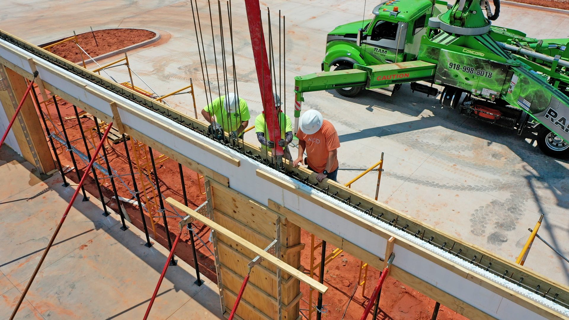Installers Pouring Concrete Into ICF Wall With Hardwall Section