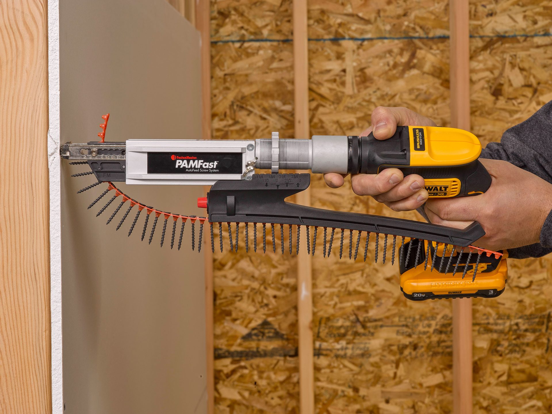 Person using a DeWalt drill with a FastenMaster PAMFast autofeed screw system on drywall.