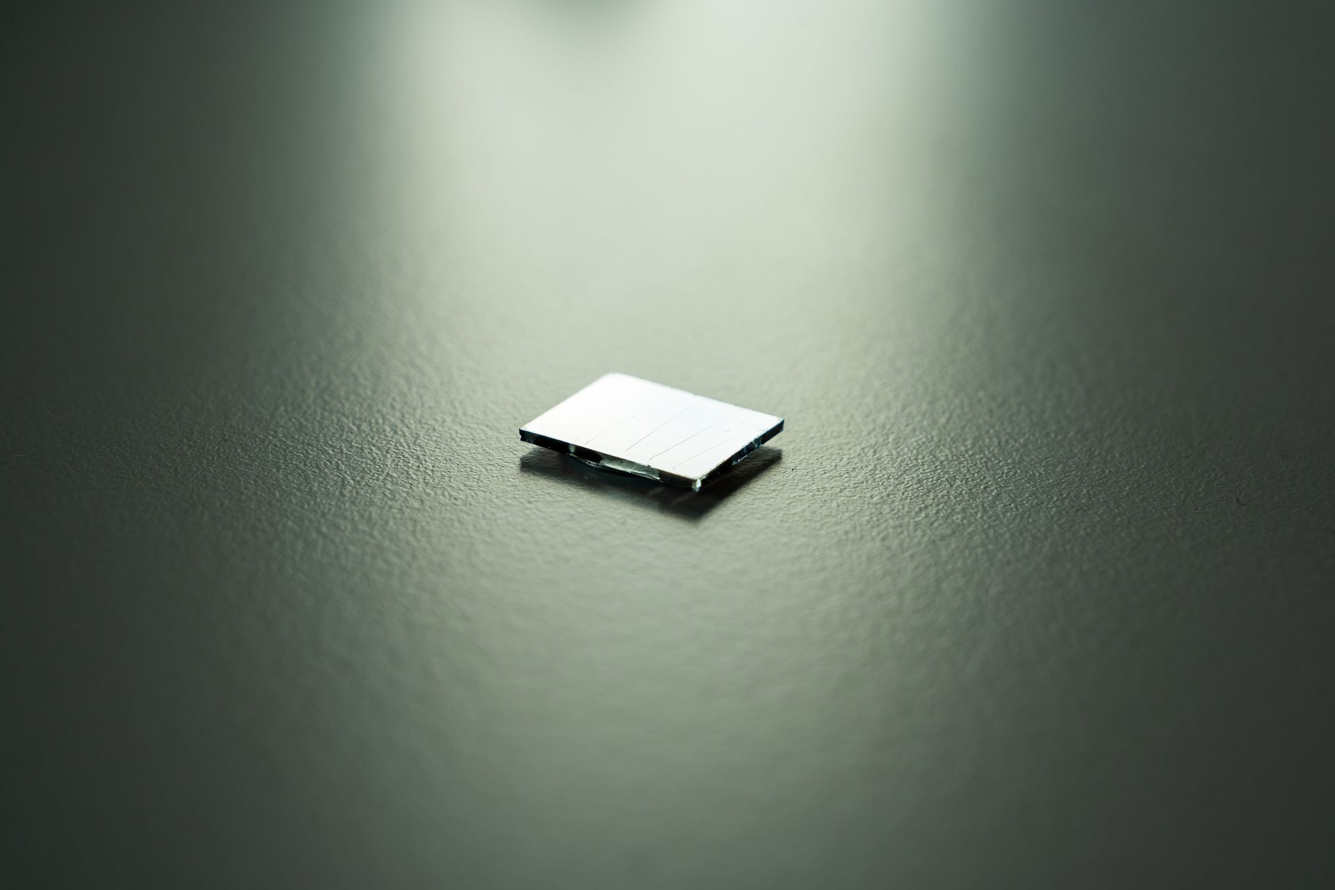 A quantum dot film deposited onto a glass substrate that has been scratched to allow measurement of the thickness.