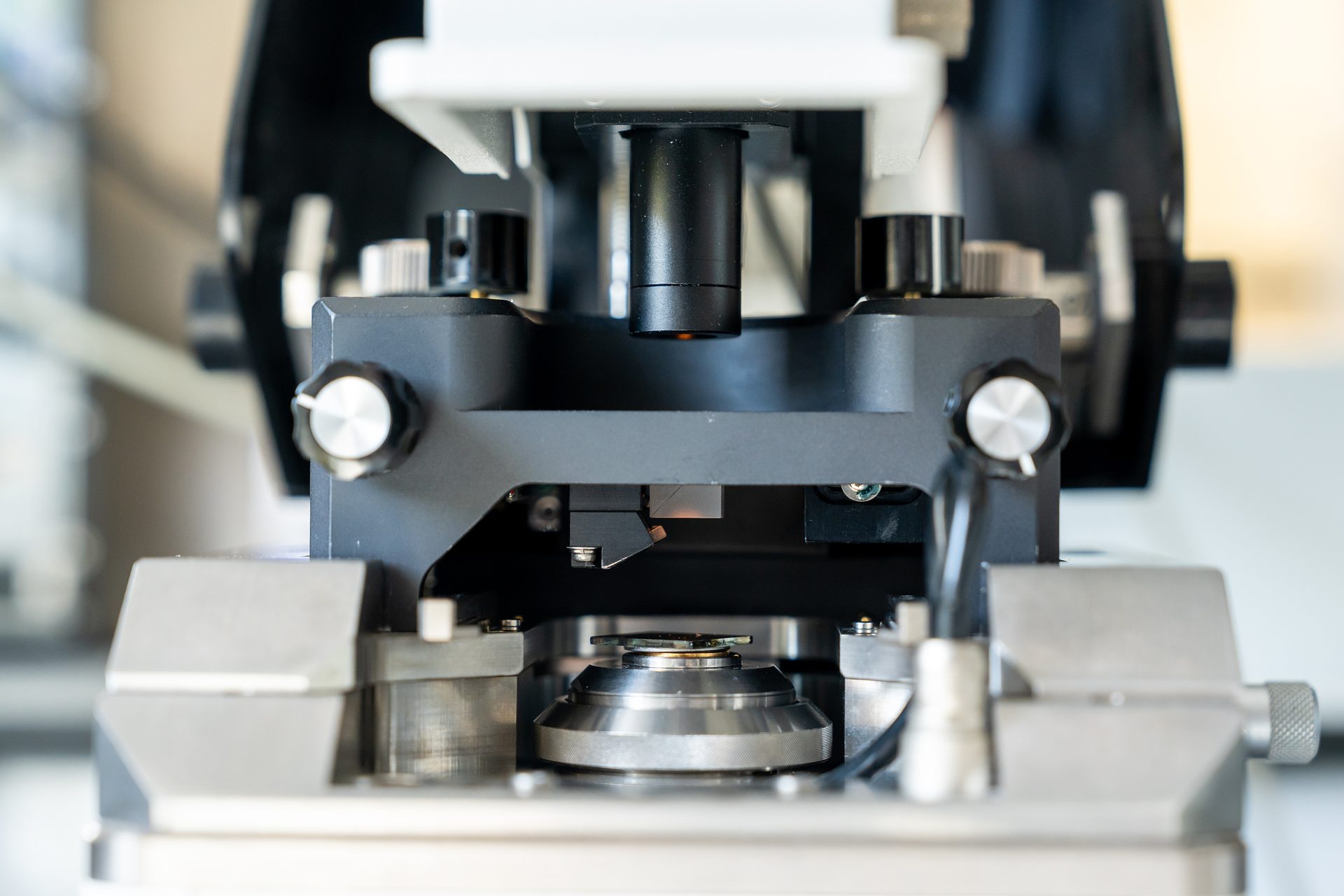 The head of an atomic force microscope (AFM) above a quantum dot film sample ready for measurement.