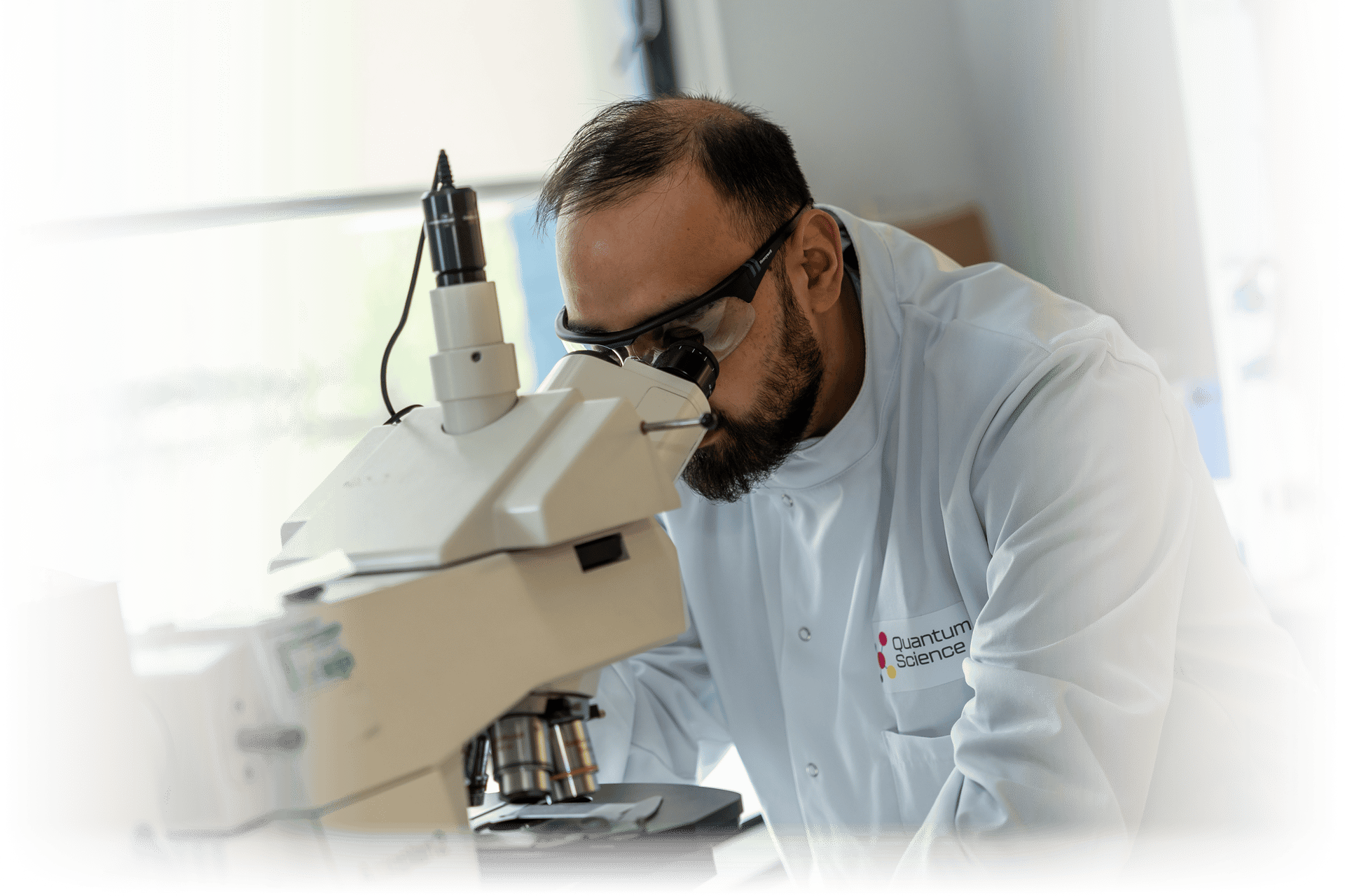 A scientist inspecting quantum dot films using an optical microscope. 