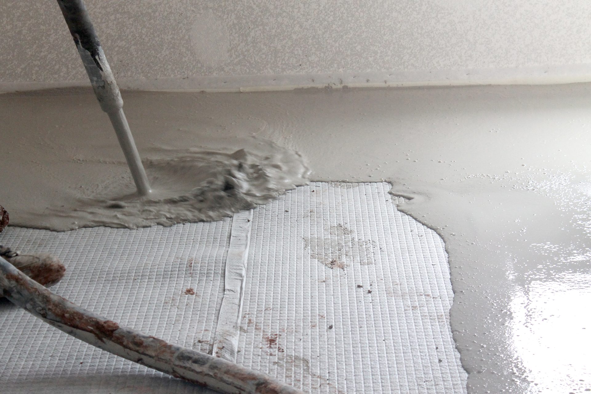 Accucrete gypsum underlayment is poured onto an Accuquiet acoustic mat