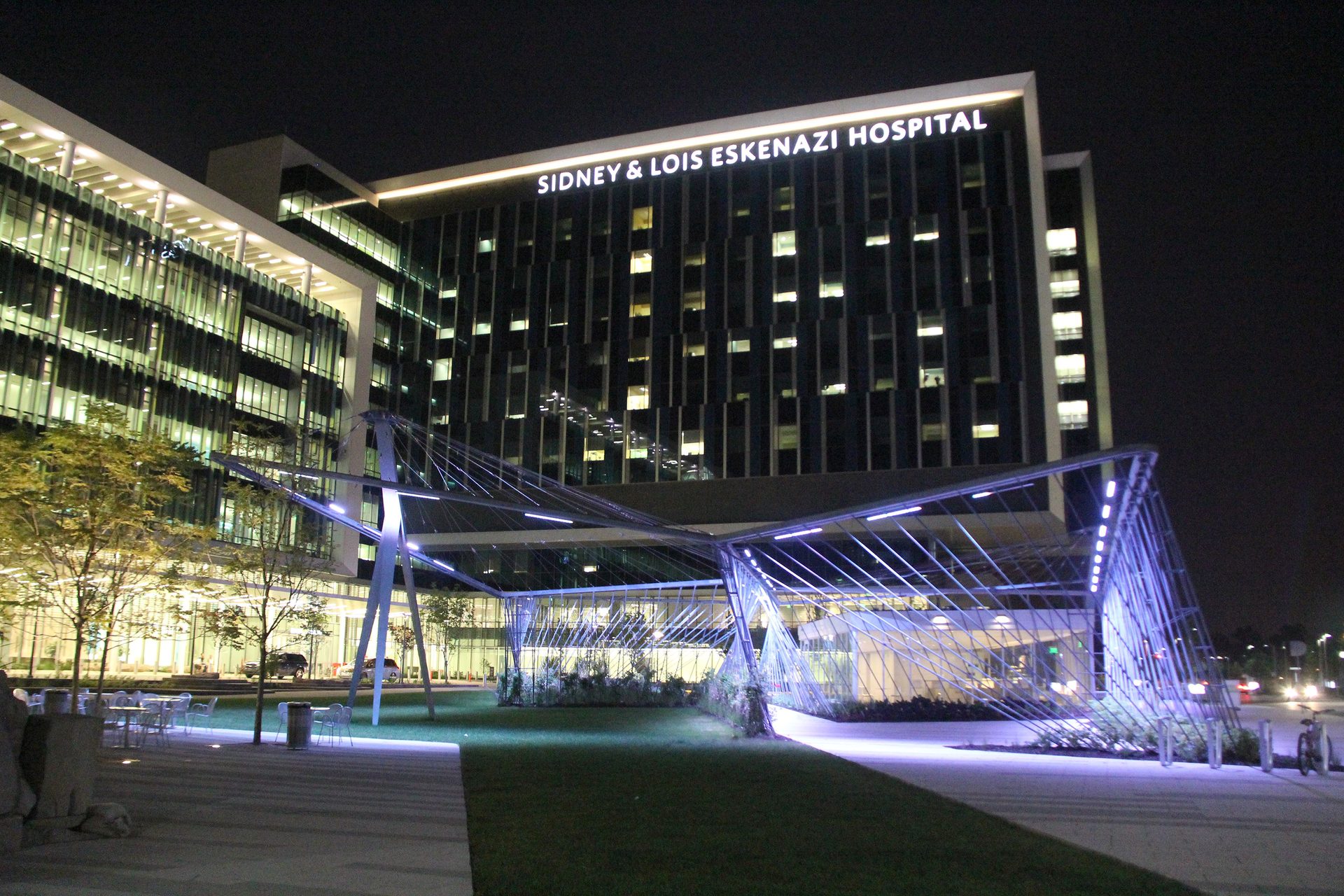 Sidney & Lois Eskenazi Hospital glowing at night, with a modern, lit canopy.