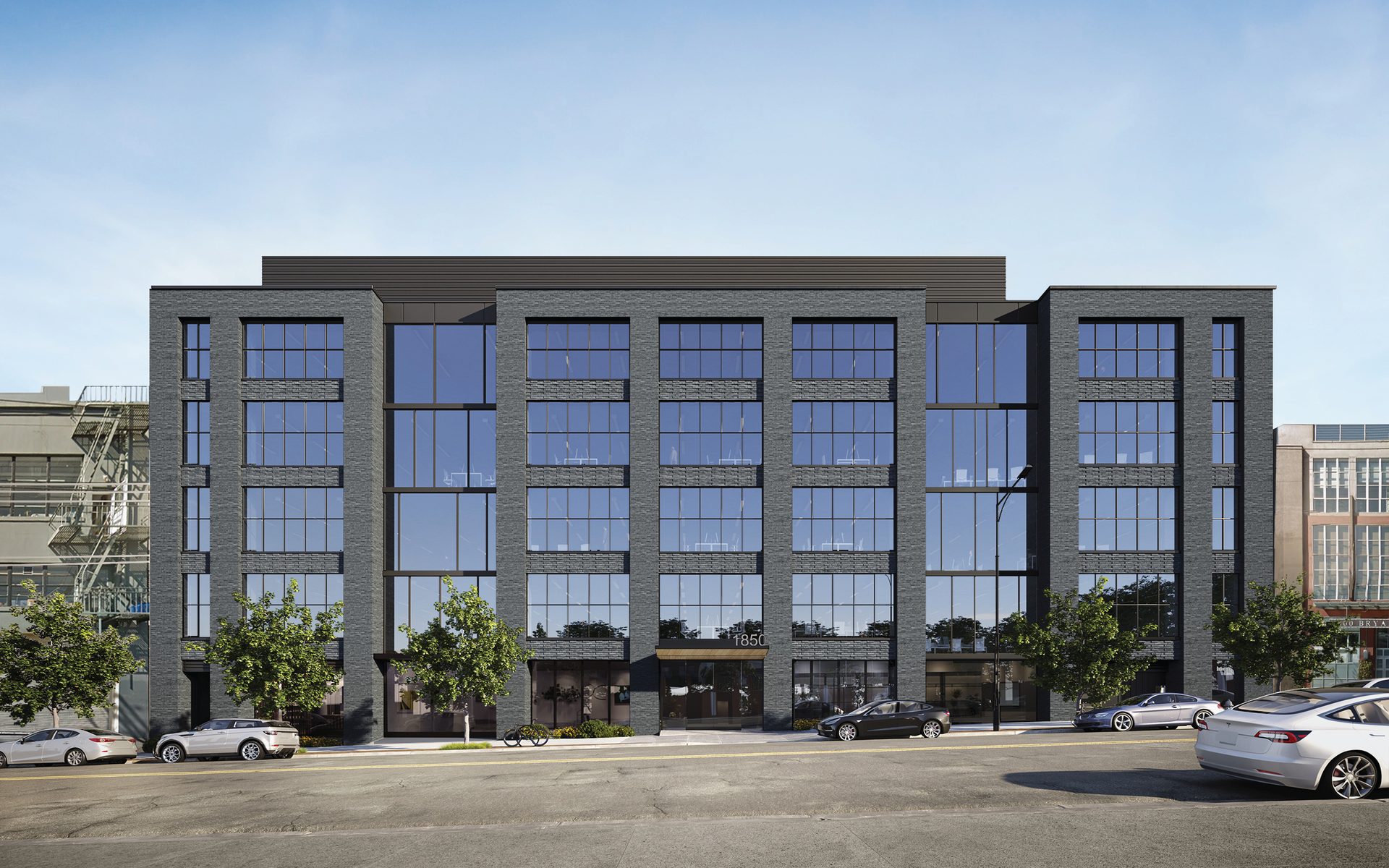 Contemporary multi-story building with dark brick and glass, street level with cars and trees.