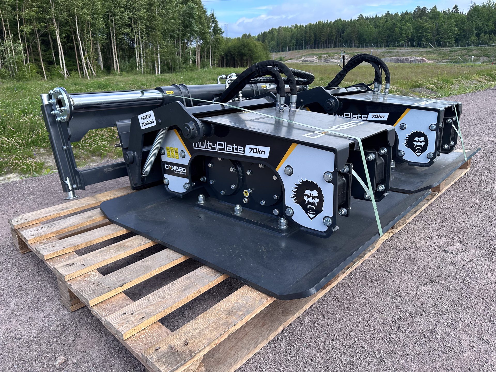 Two CANGED MultiPlate 70kn vibratory plate compactors with gorilla logos on a wooden pallet outdoors.