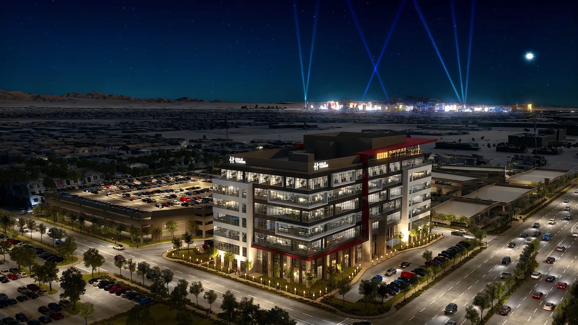 Night aerial view of Halo Tower office building, city, mountains, searchlights, and starry sky.