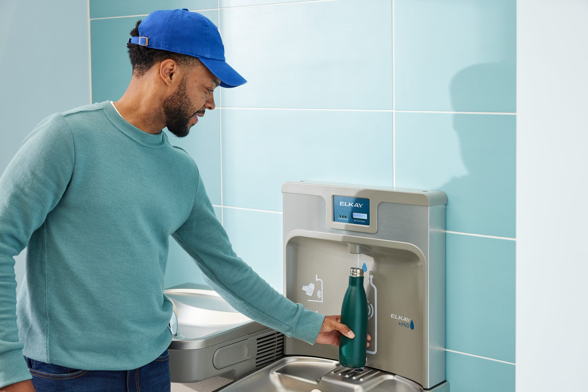 Kitchen sink, Plumbing fixture, Baseball cap, Shoulder, Tap, Blue, Sleeve, Fluid