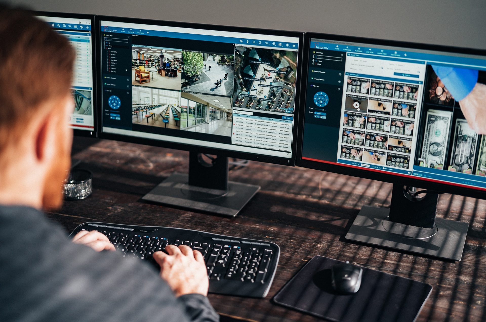 Person monitors multi-screen security system with diverse surveillance camera views and timelines.