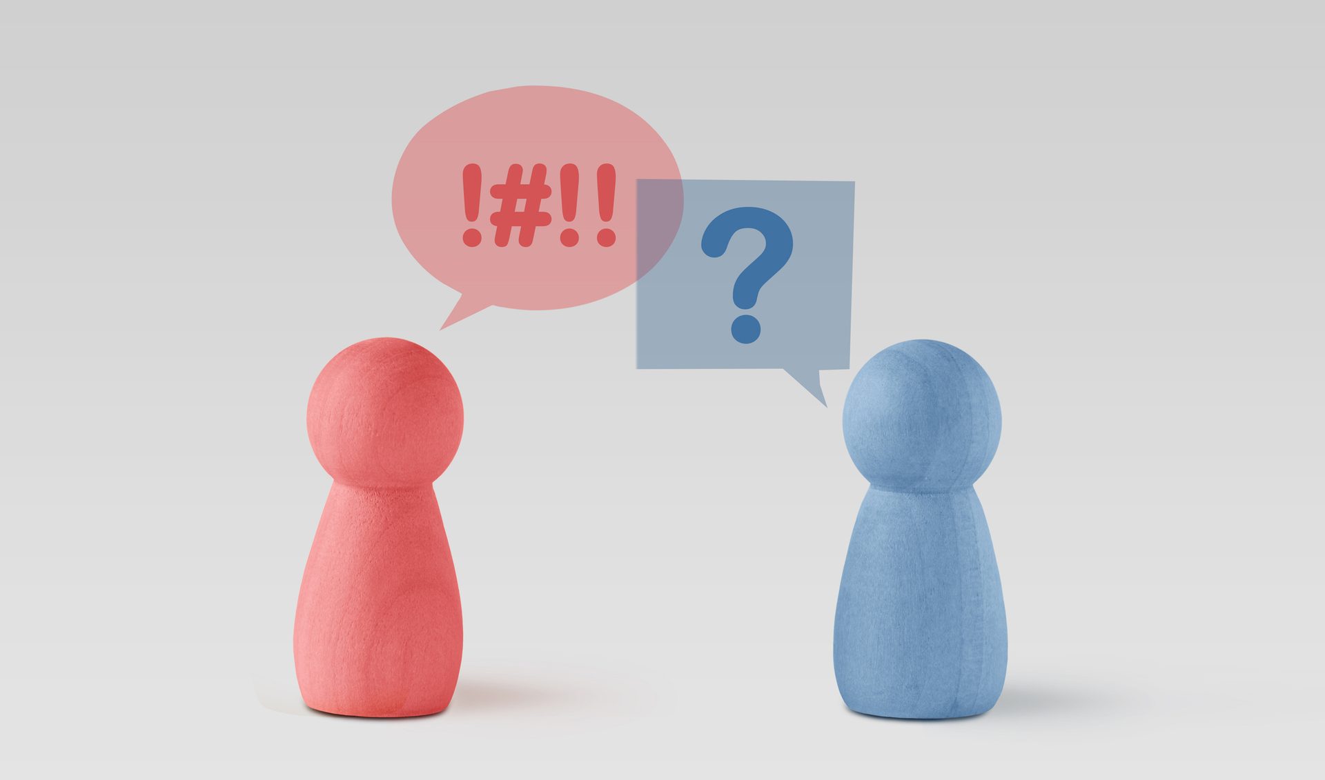 Two wooden figures, red expressing anger (!#!!) and blue showing confusion (?).