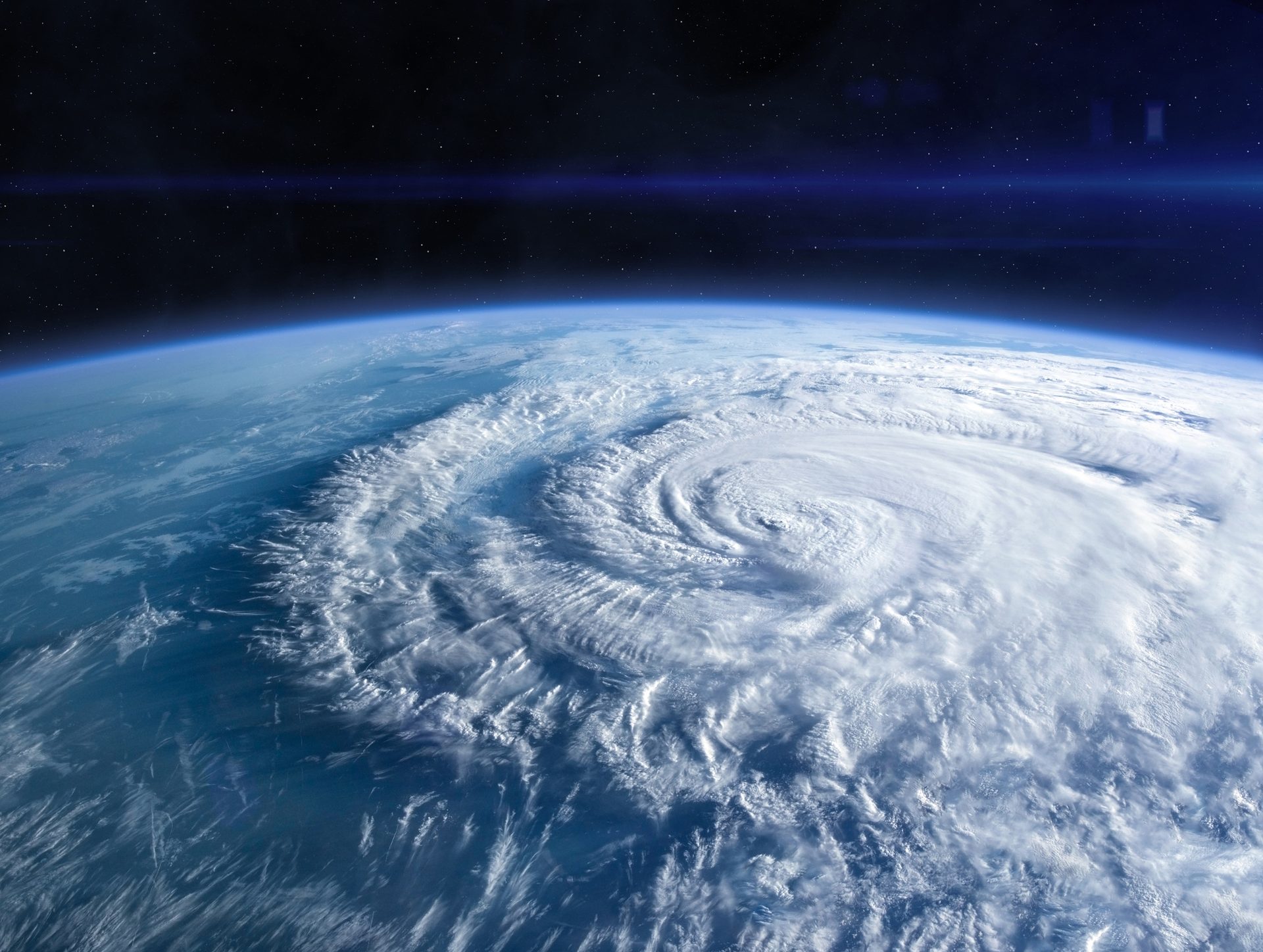 Earth from space with a hurricane, curved horizon, and stars.