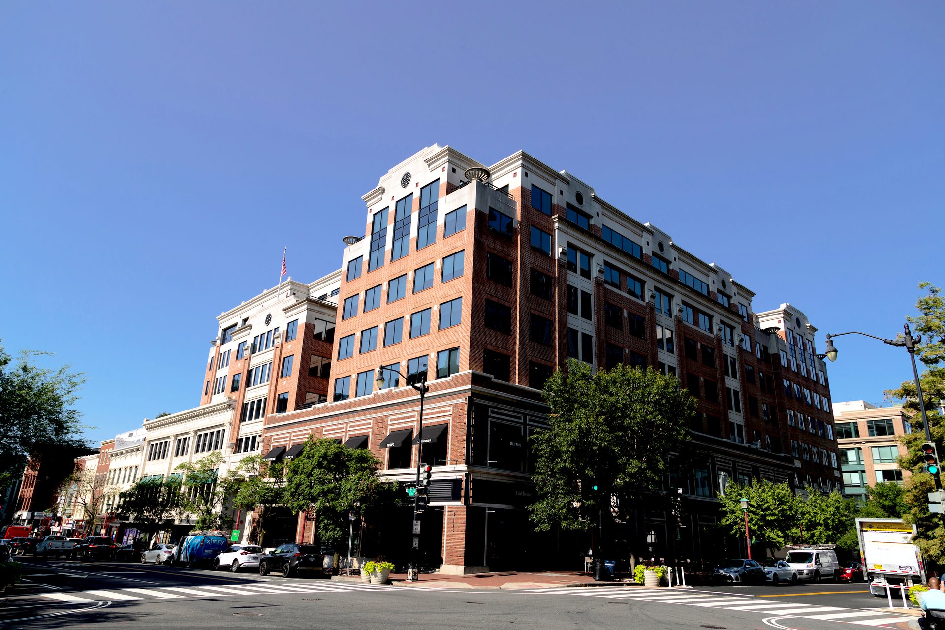 Red brick building at a city intersection under a clear blue sky.