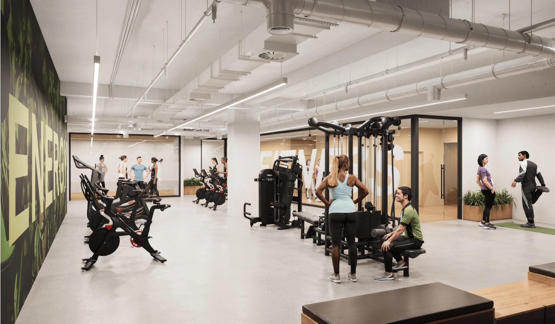 Bright, modern gym with people exercising on various equipment and stretching.