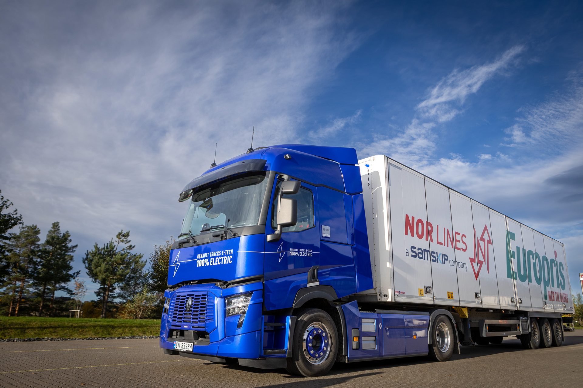 A blue Renault E-Tech 100% electric truck with a white trailer displaying "Nor Lines" and "Europris".
