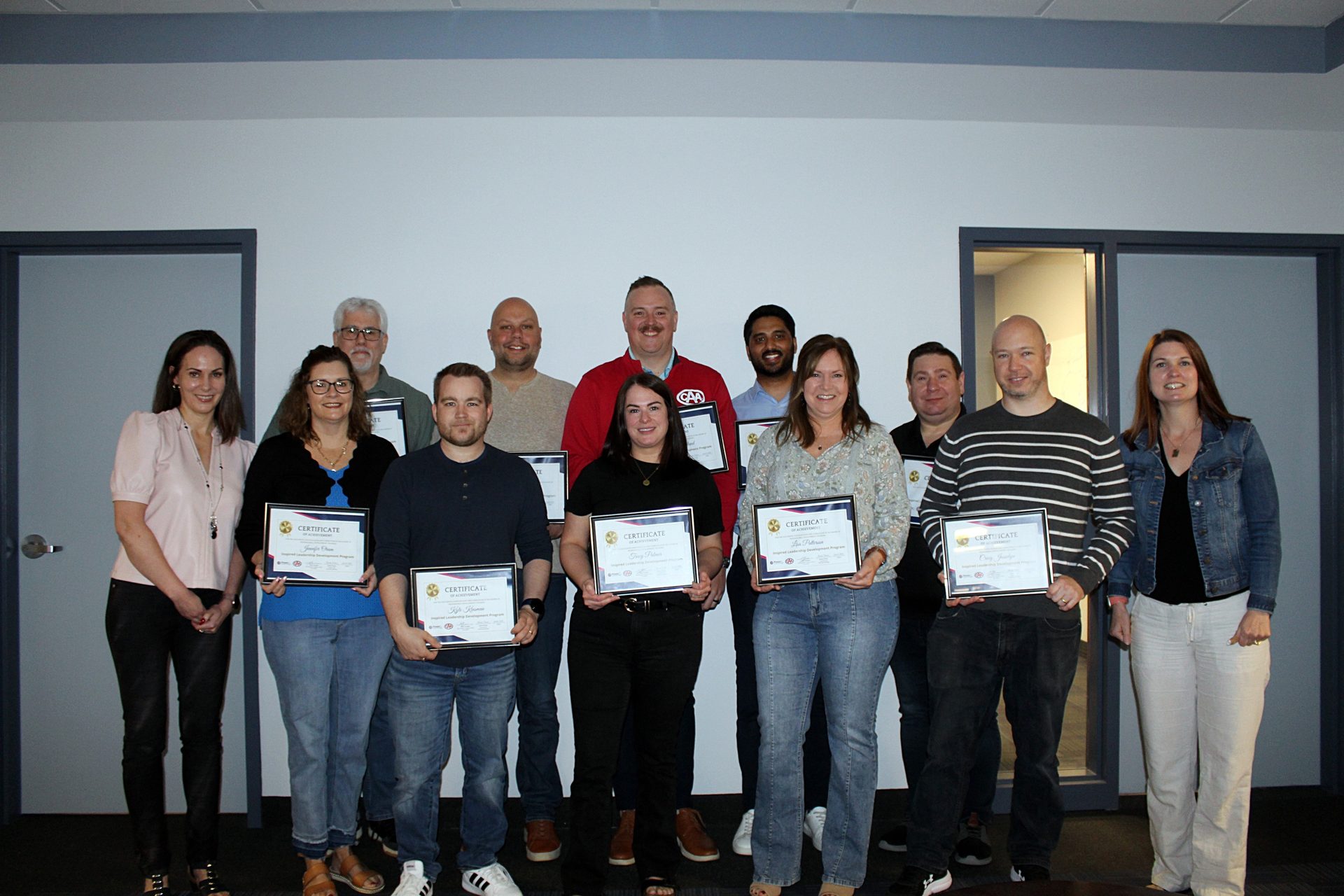 A group of people, some holding certificates, standing together for a photo.