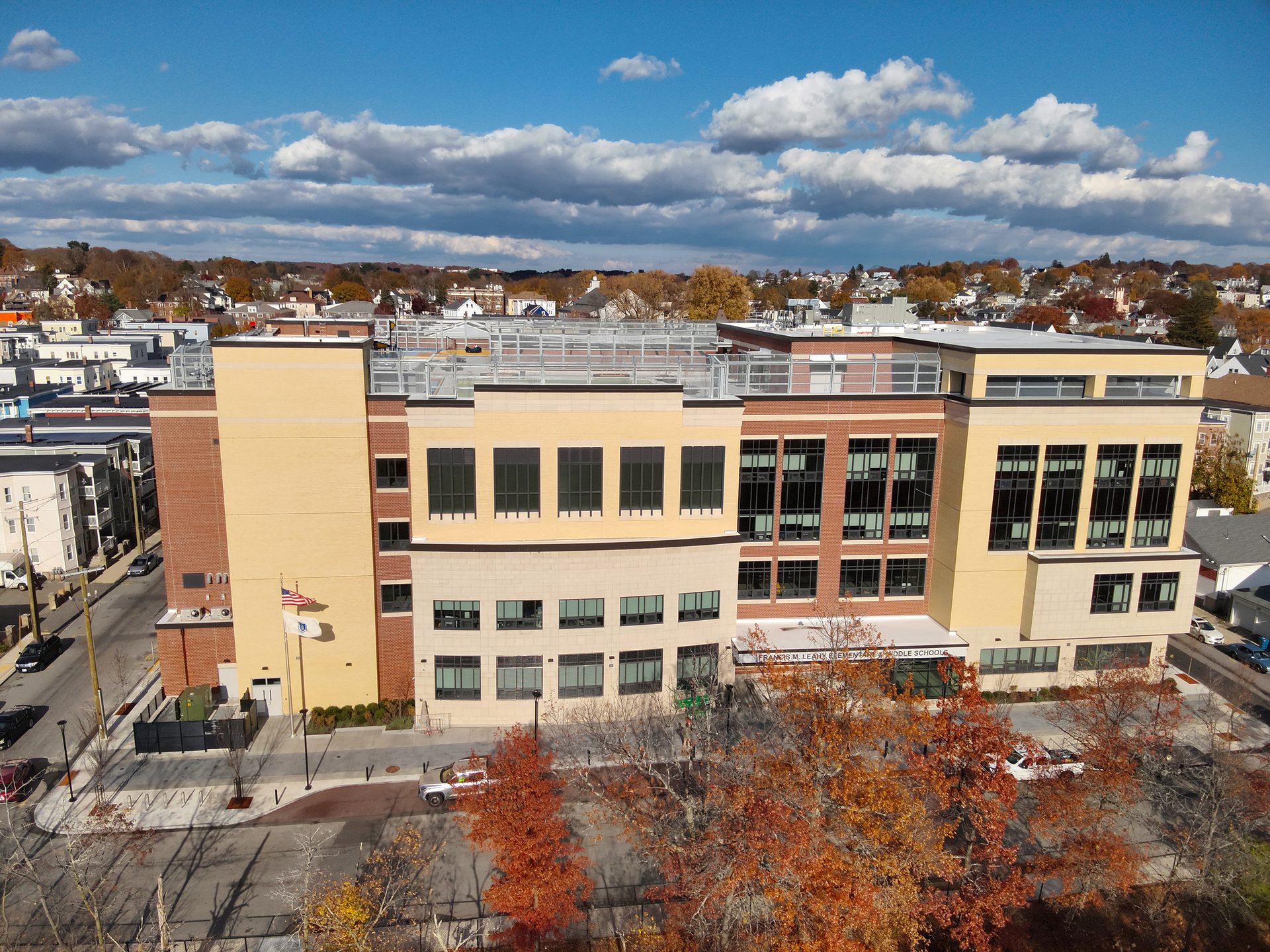 Aerial view of Francis W. Leahy Elementary & Middle School, a modern building with fall trees under a cloudy sky.