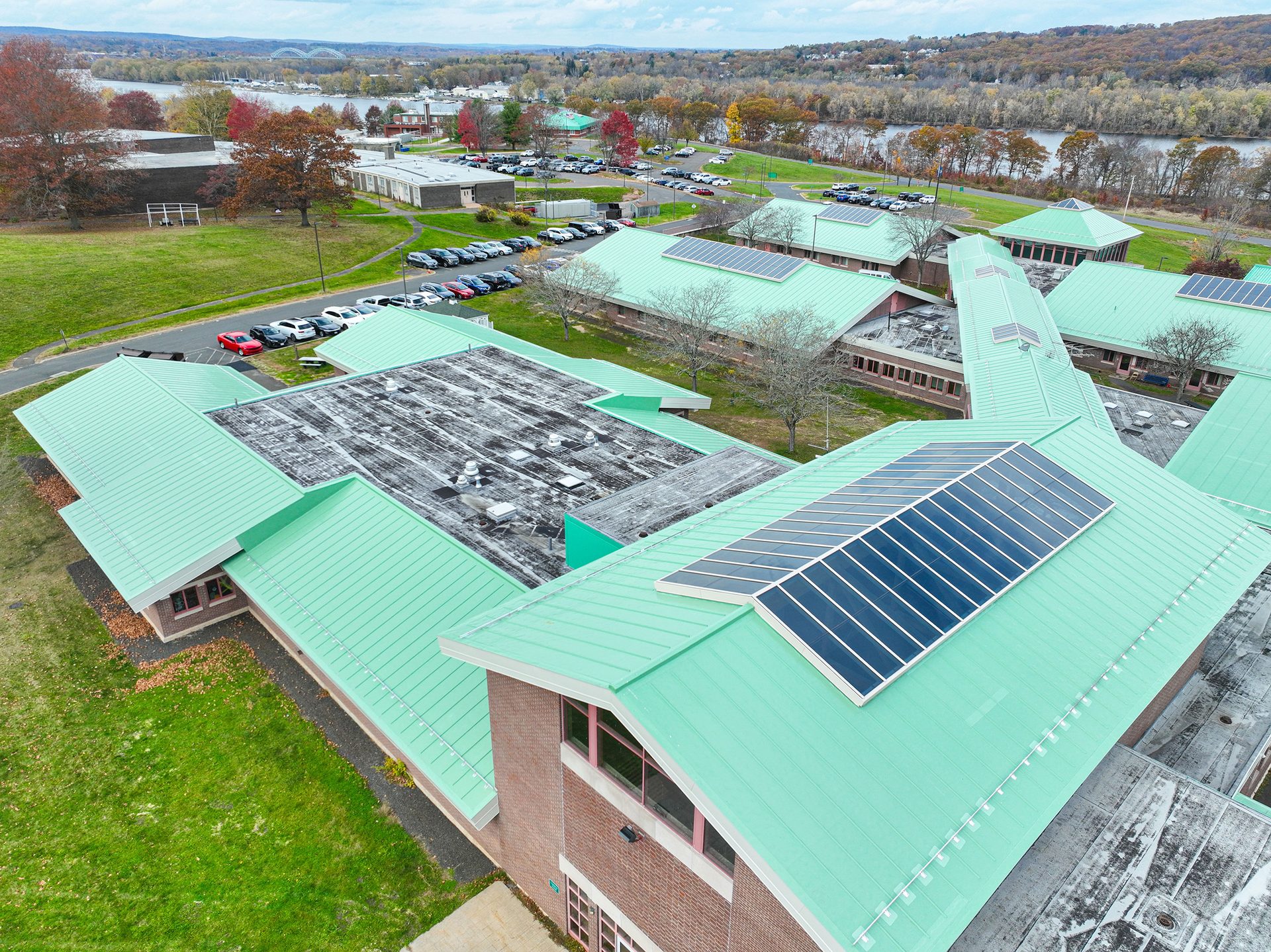 Aerial view of a school campus featuring multiple buildings with green roofs and solar panel installations.