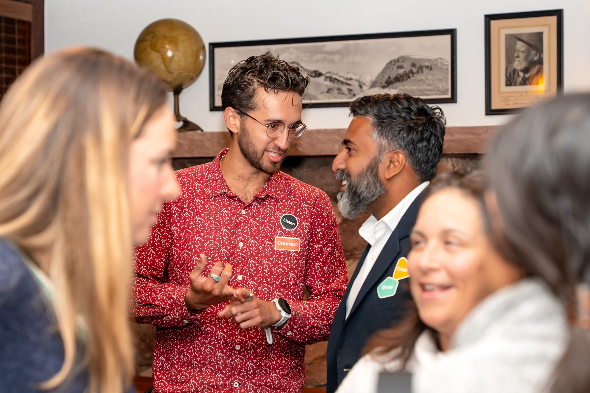 Two men with name tags "Listen" and "Connect" are conversing, surrounded by blurred faces.