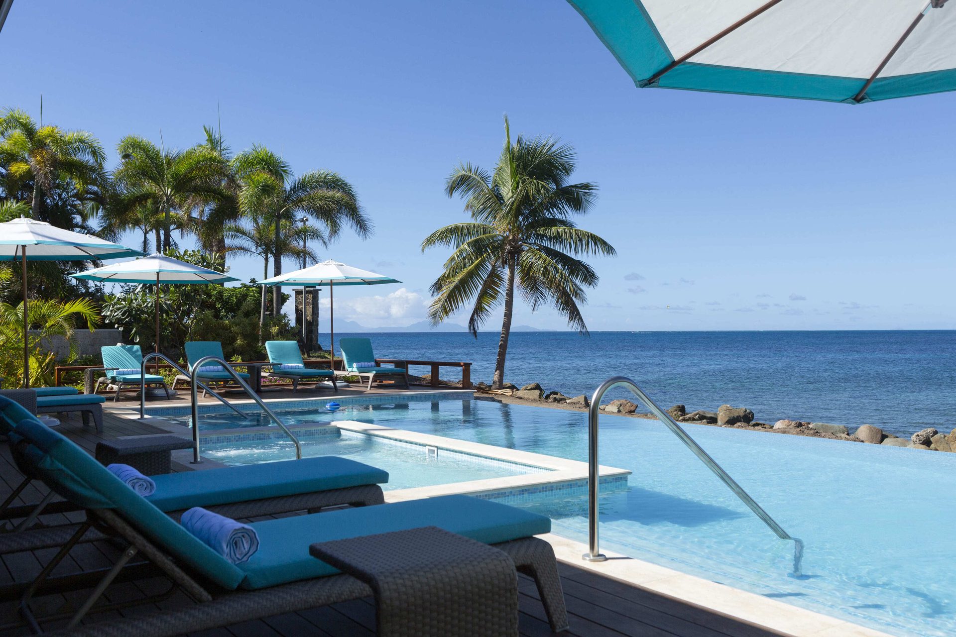 Seaside resort, Outdoor furniture, Swimming pool, Water, Sky, Property, Light, Azure, Shade, Tree