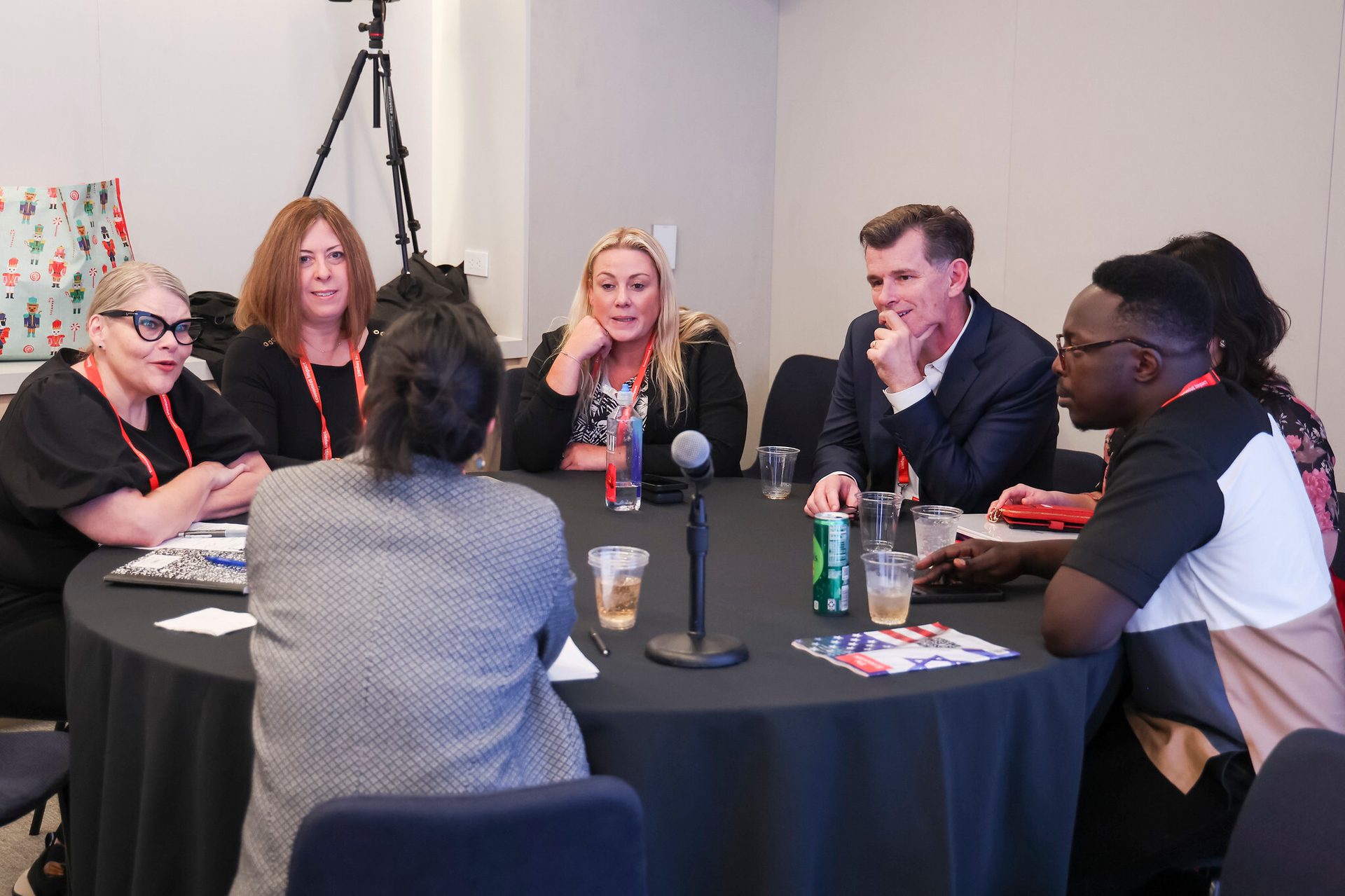 Diverse group attending a roundtable discussion with a microphone.
