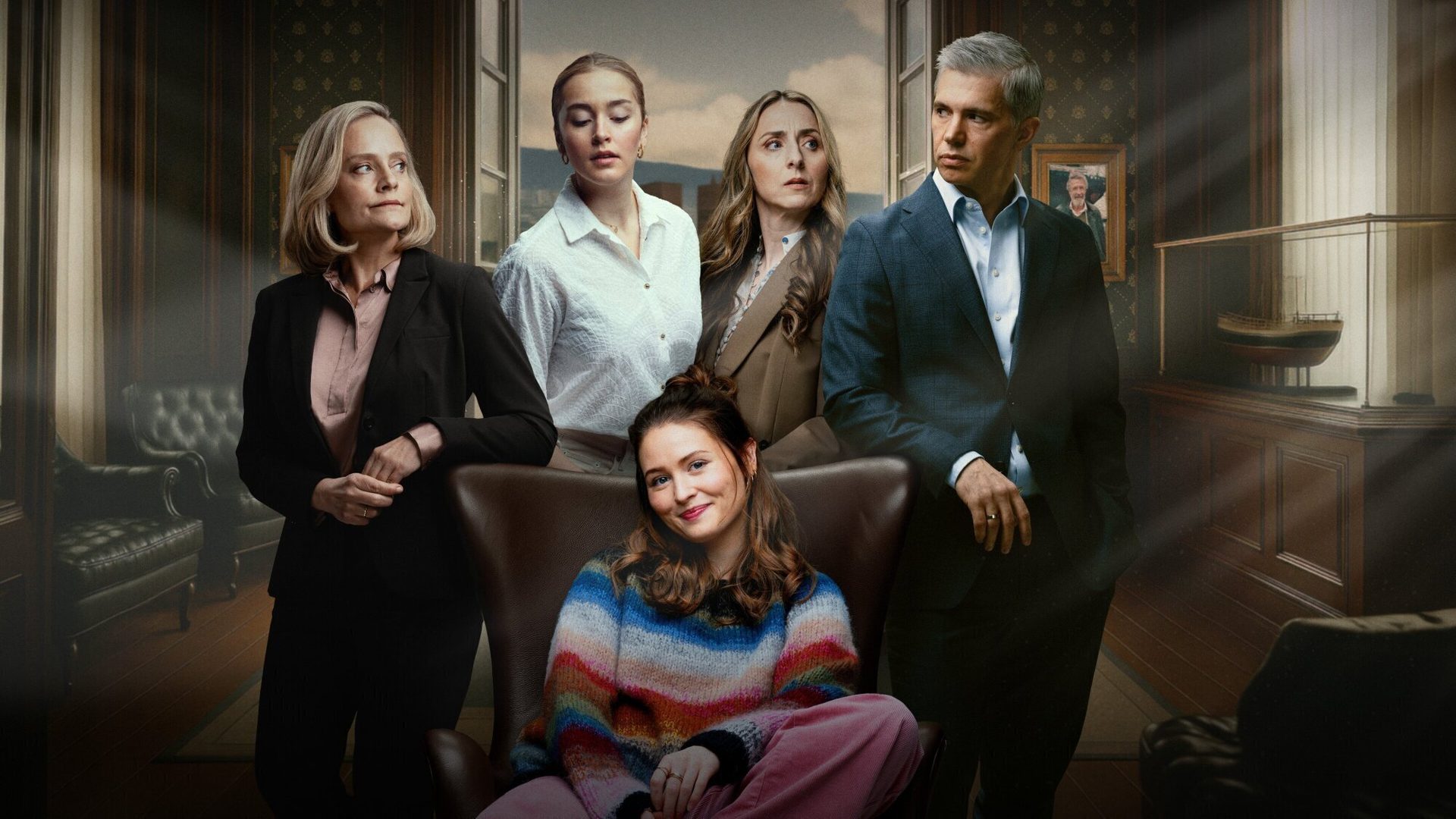 Six people, one young woman smiling seated, others standing, in a formal room with ornate decor.