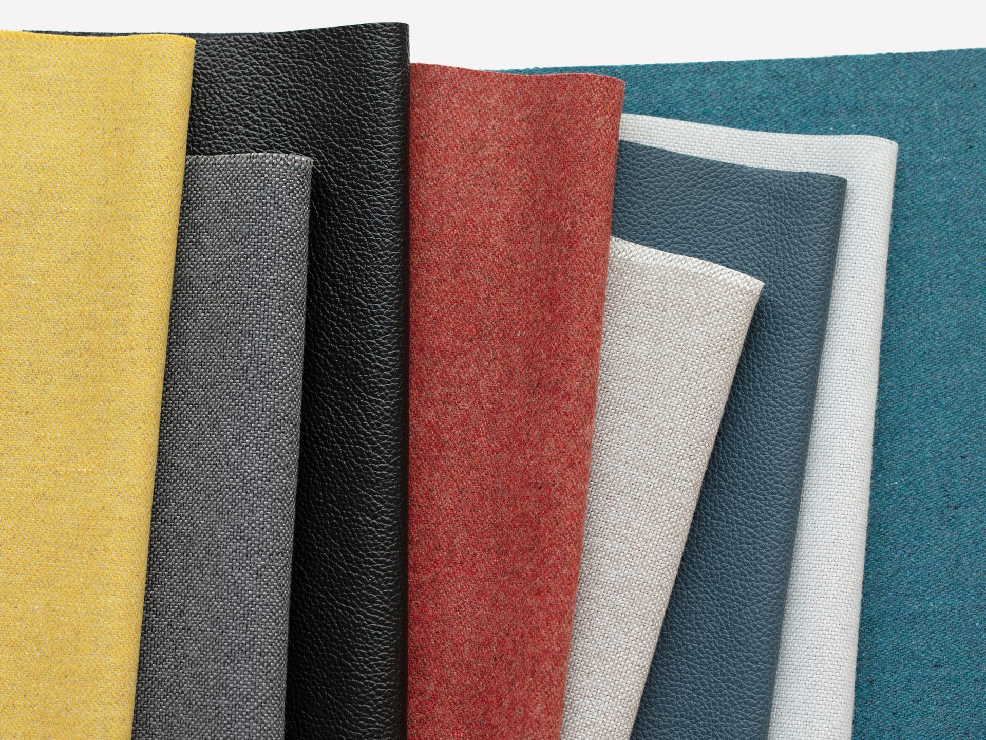 Diverse stacked fabric samples showing colors and textures.