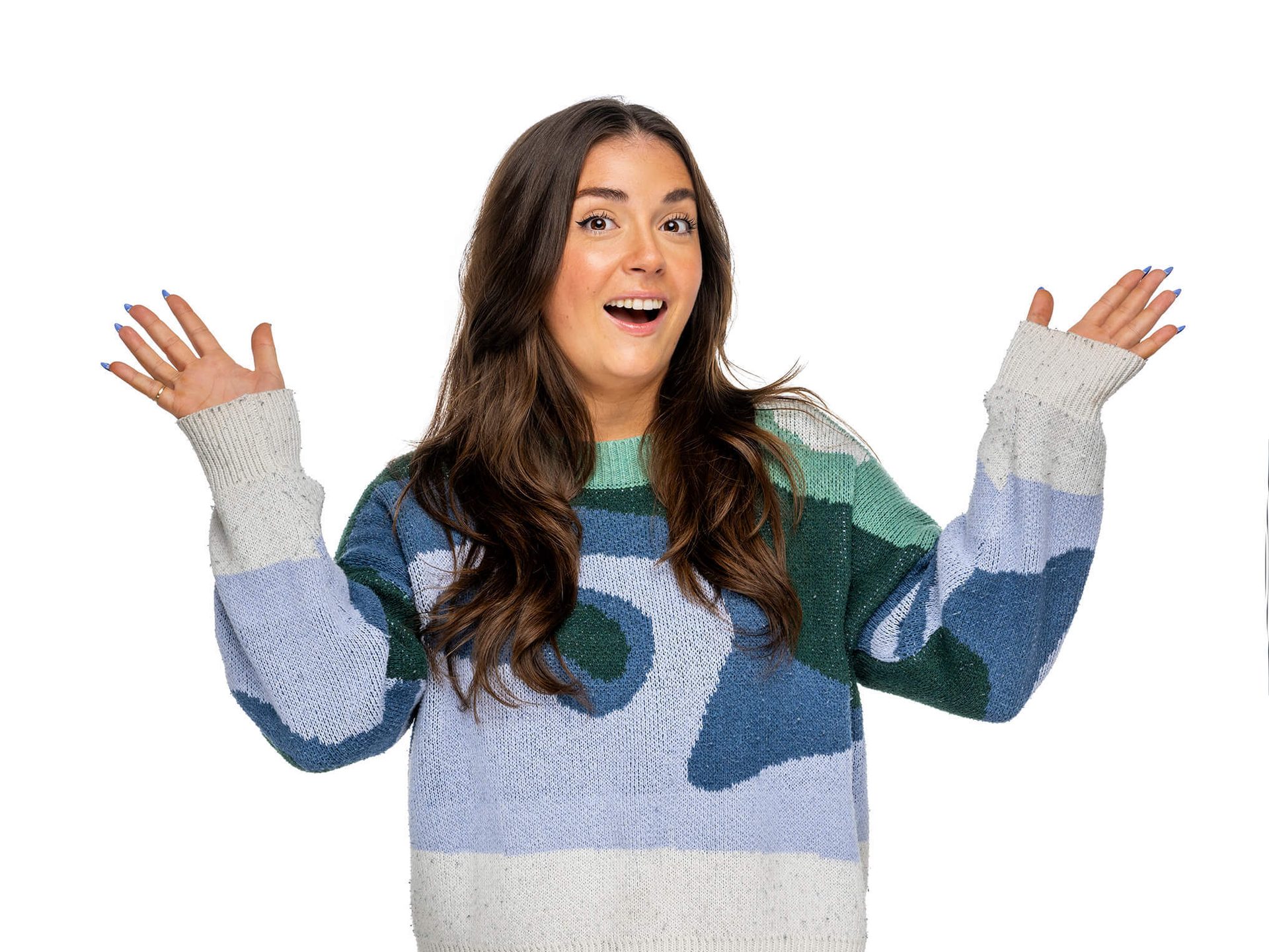 A surprised woman in a colorful sweater, with hands raised and mouth open, on a white background.
