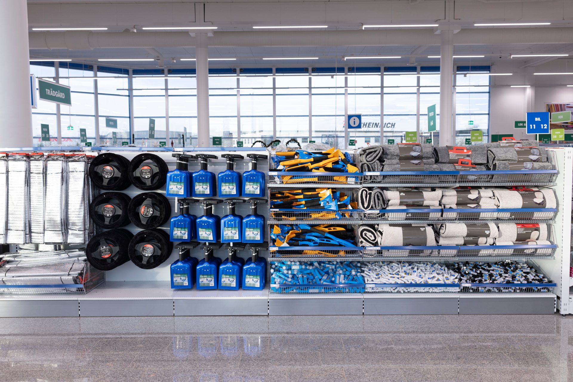Car care and accessory aisle with sprays, wheel covers, ice scrapers, and mats.
