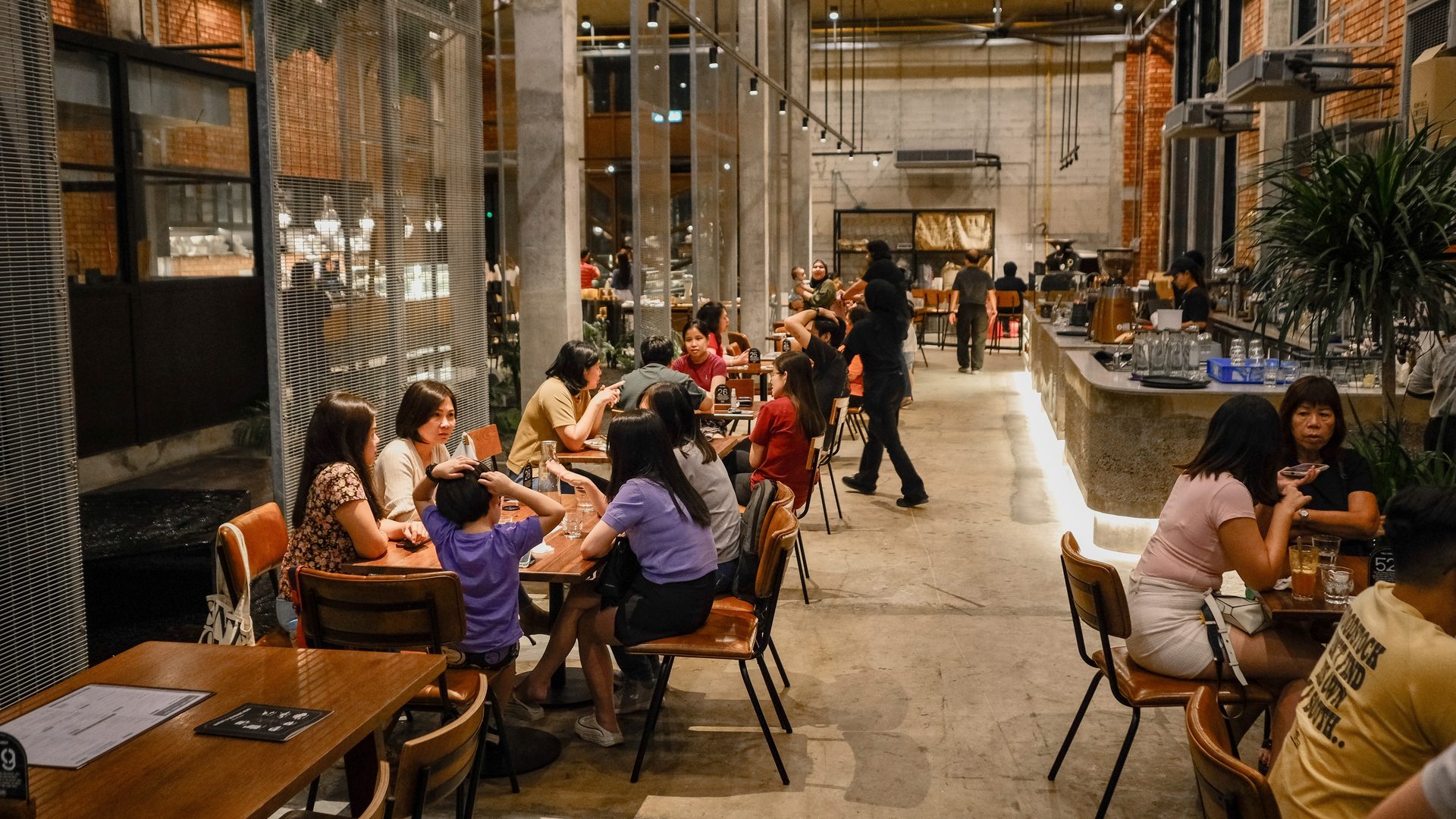 Busy industrial-style restaurant filled with diners.