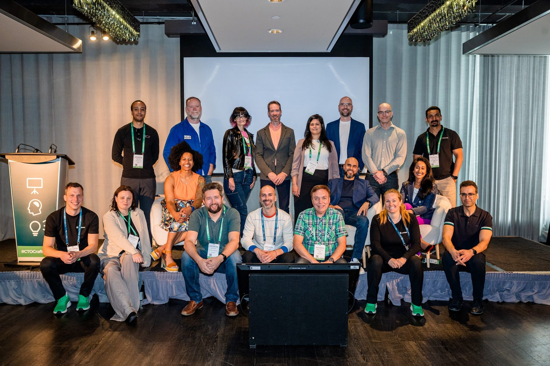 Group photo of diverse professionals at a conference, some standing, some seated.