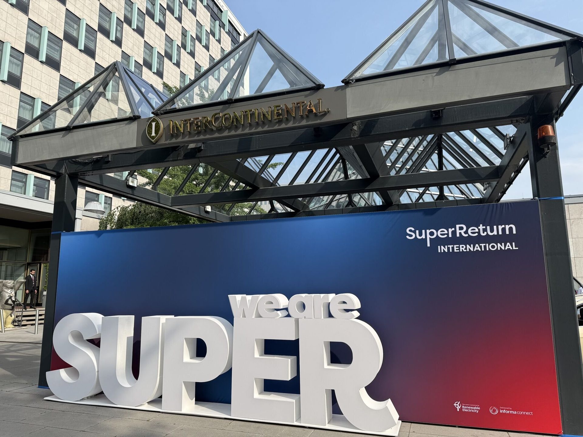 Large "we are SUPER" sign for SuperReturn International event outside InterContinental hotel.