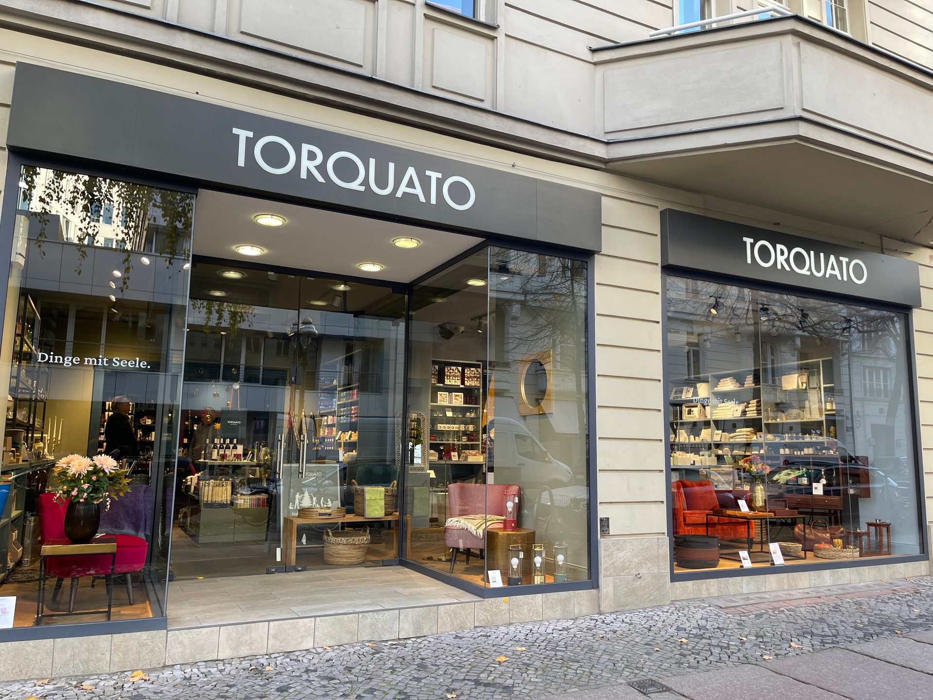 A TORQUATO storefront with large glass windows showcasing home decor and furnishings.