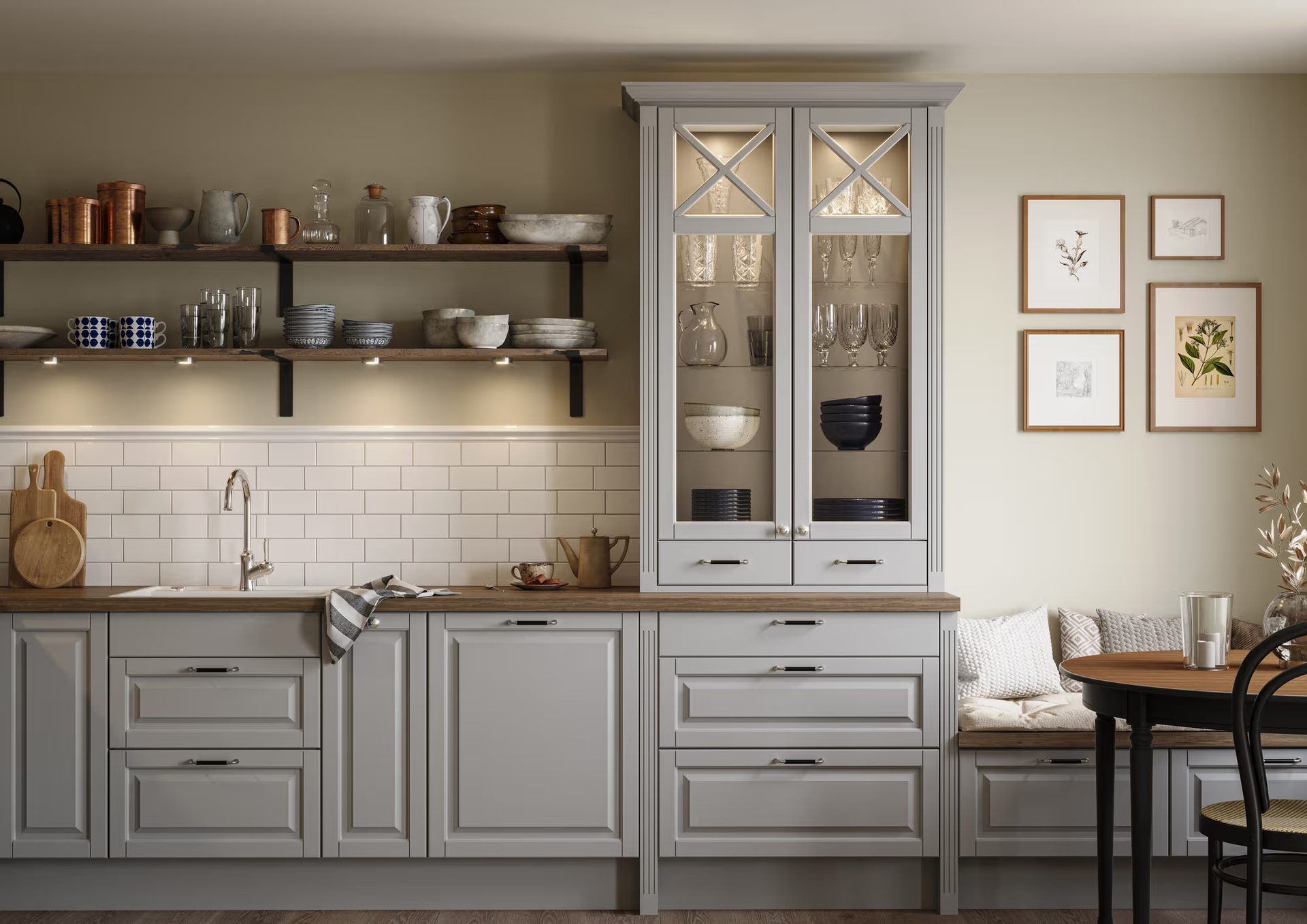 Farmhouse-style kitchen with light gray cabinets, wooden counters, open shelving, and a dining bench.