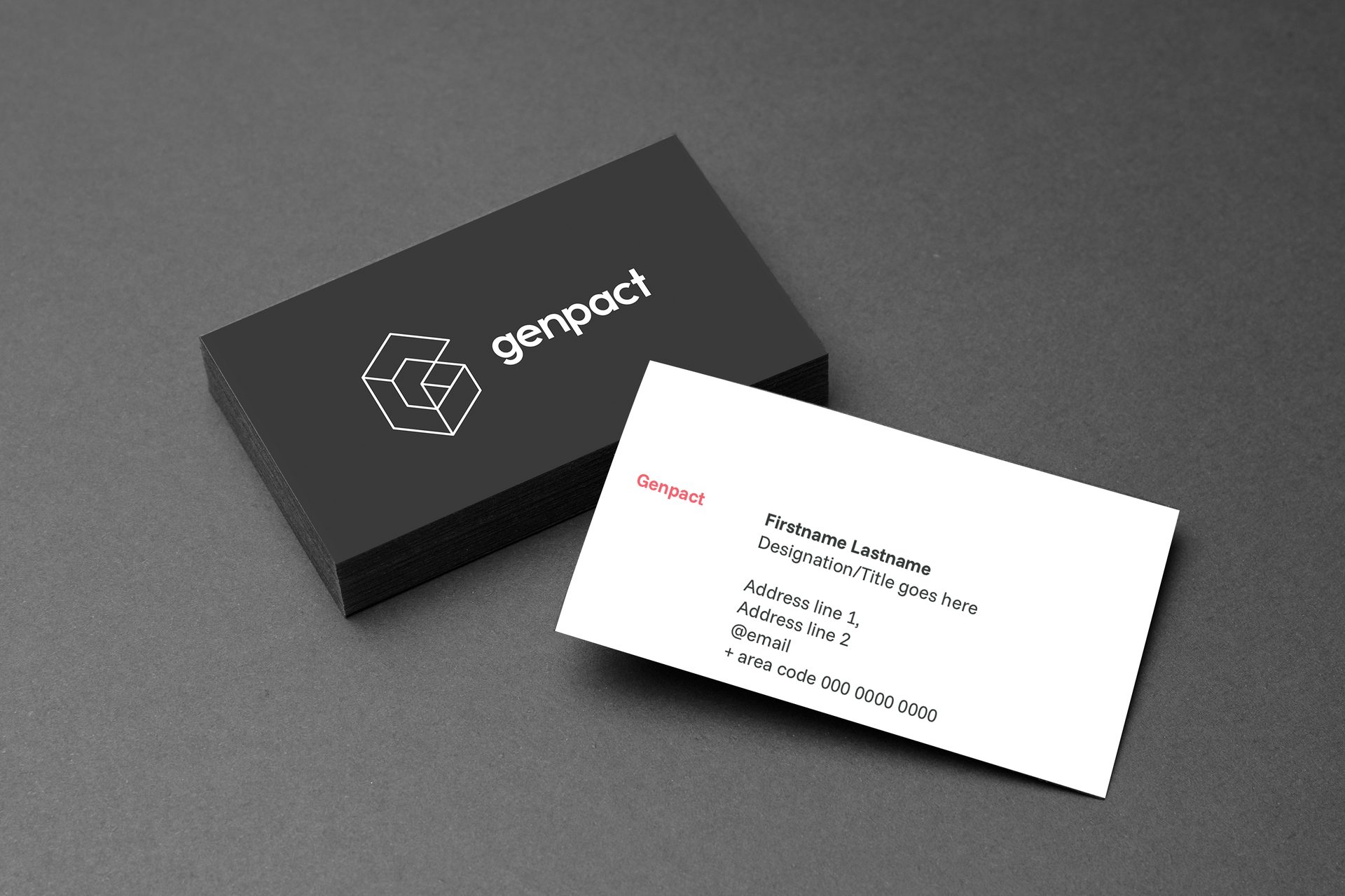 Stack of black Genpact business cards and a white card with contact info.