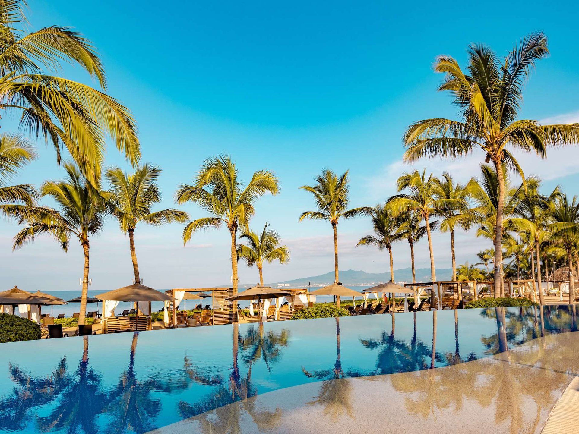 Seaside resort, Swimming pool, Natural landscape, Water, Sky, Property, Azure, Plant, Building, Tree