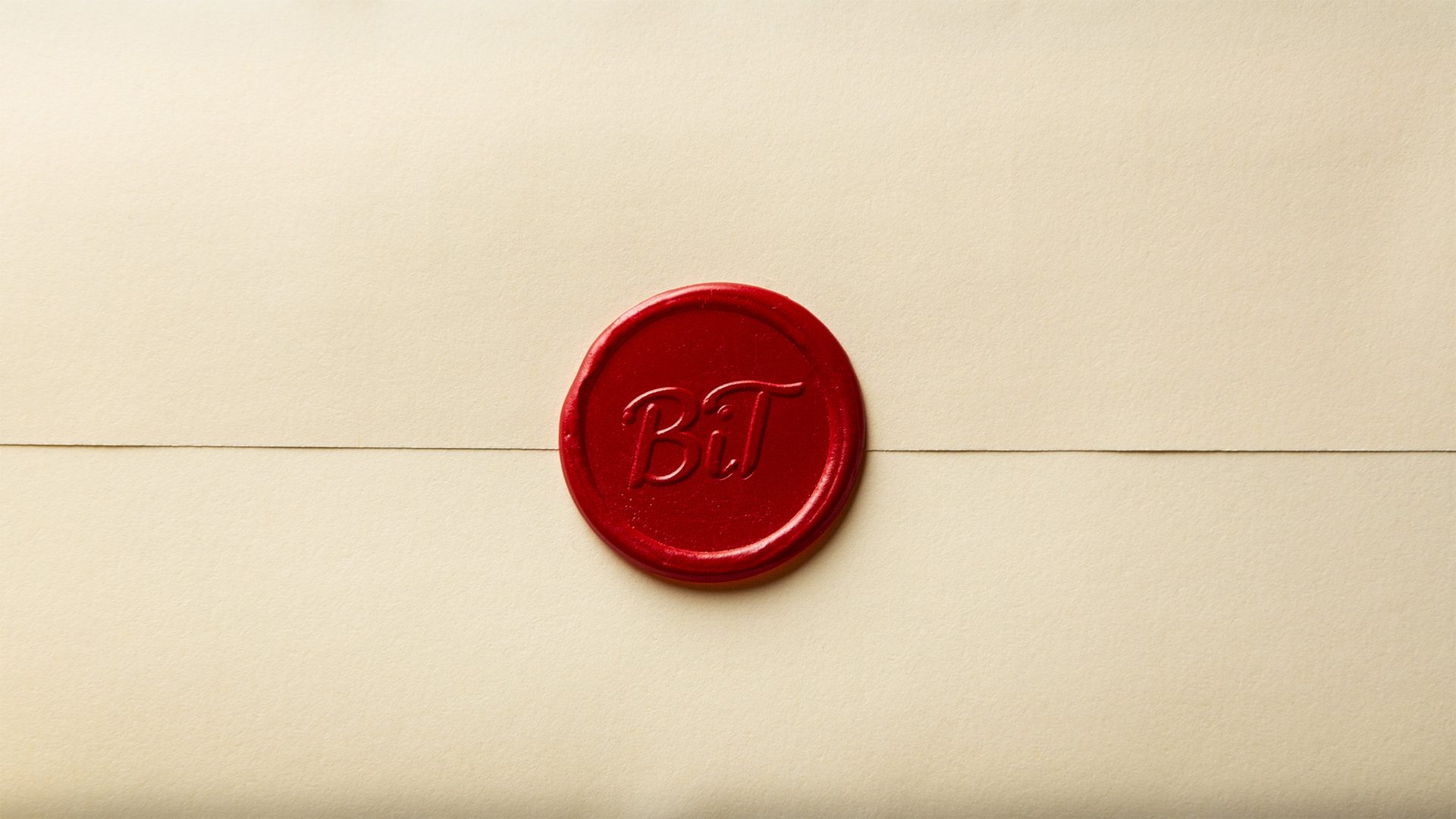 Red wax seal with "BT" initials on a cream envelope.