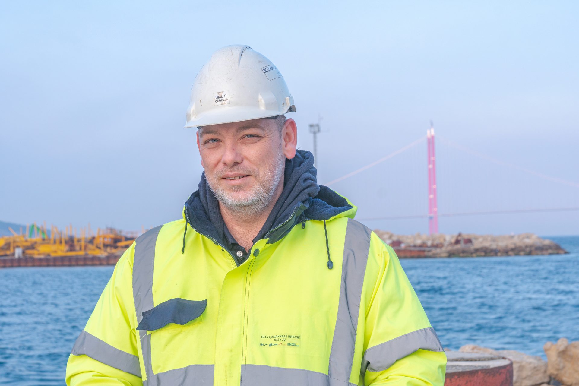 Hard hat, High-visibility clothing, Water, Outerwear, Sky, Helmet, Workwear, Engineer, Sleeve, Headgear