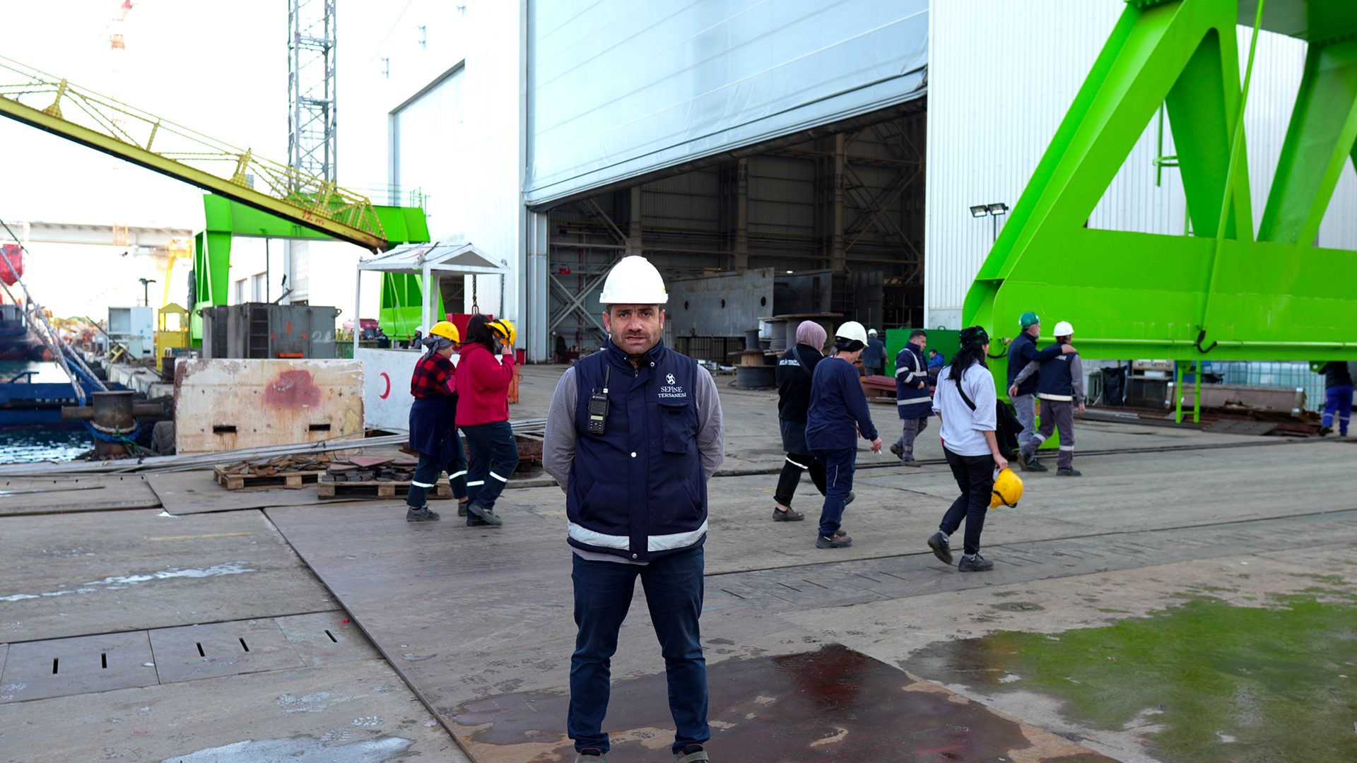 Road surface, High-visibility clothing, Green, Infrastructure, Asphalt, Jacket, Sidewalk, Building