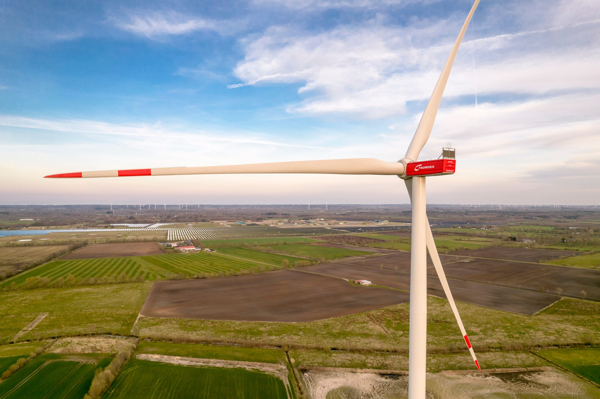 Land lot, Natural landscape, Wind farm, Air travel, Cloud, Sky, Windmill, Aircraft, Vehicle