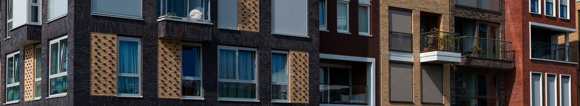 closeup of windows on an older apartment building featuring different types of brick styles