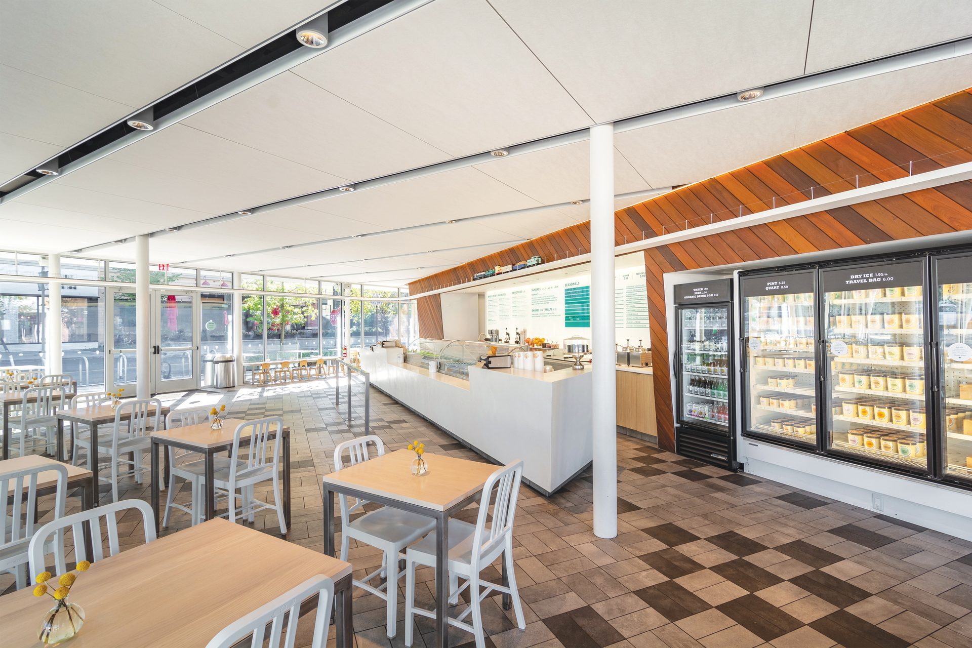 Bright interior of an ice cream shop with white ceiling and wood finished wall system.