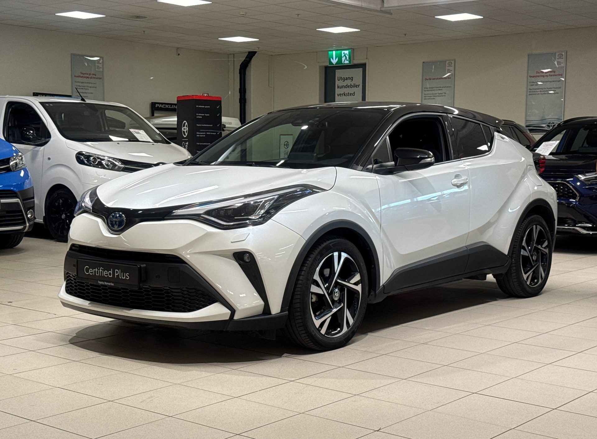 White Toyota C-HR "Certified Plus" car in a showroom.