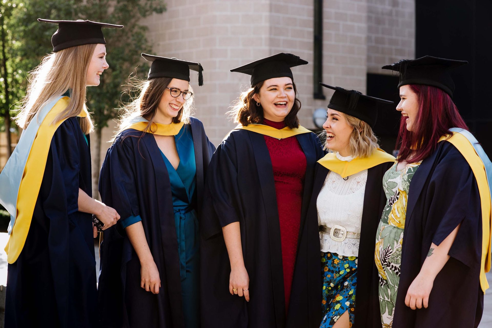 Facial expression, Academic dress, Social group, Smile, Mortarboard, Scholar, Sleeve, Gesture, Interaction, Headgear