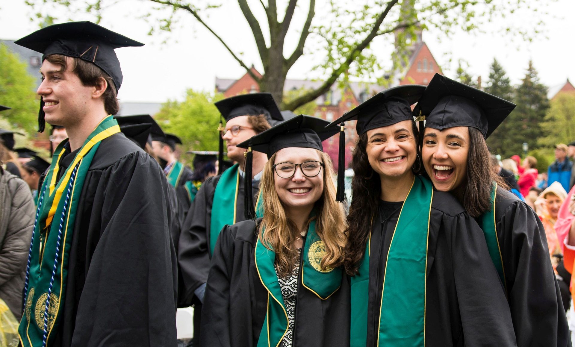 Clothing, Smile, Outerwear, Green, Black, Tree, Hat, Mortarboard, Gesture, Happy