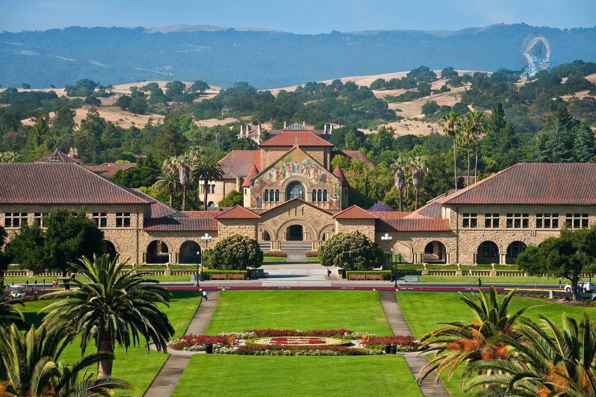 Grand view of Stanford University's Memorial Church and Main Quadrangle, with lush lawns and distant hills.