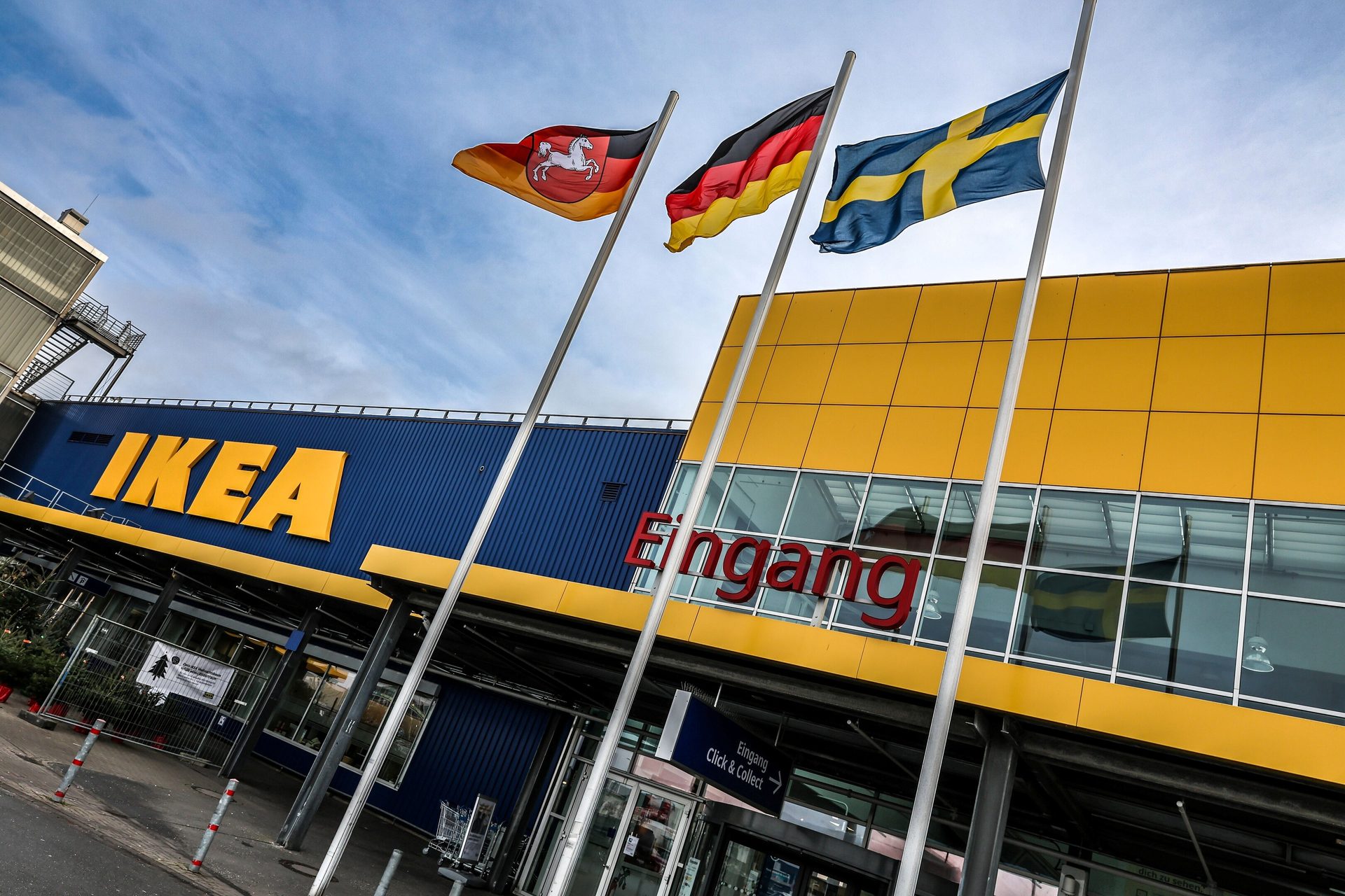 IKEA store exterior with blue and yellow facade, IKEA logo, and flags of Lower Saxony, Germany, Sweden.