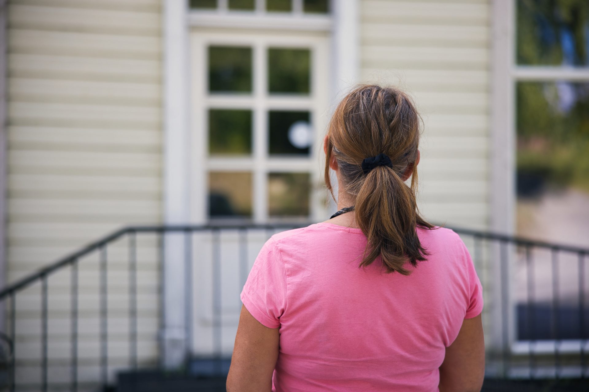 Bilde av Sidsel som st&#xE5;r fremfor et hus