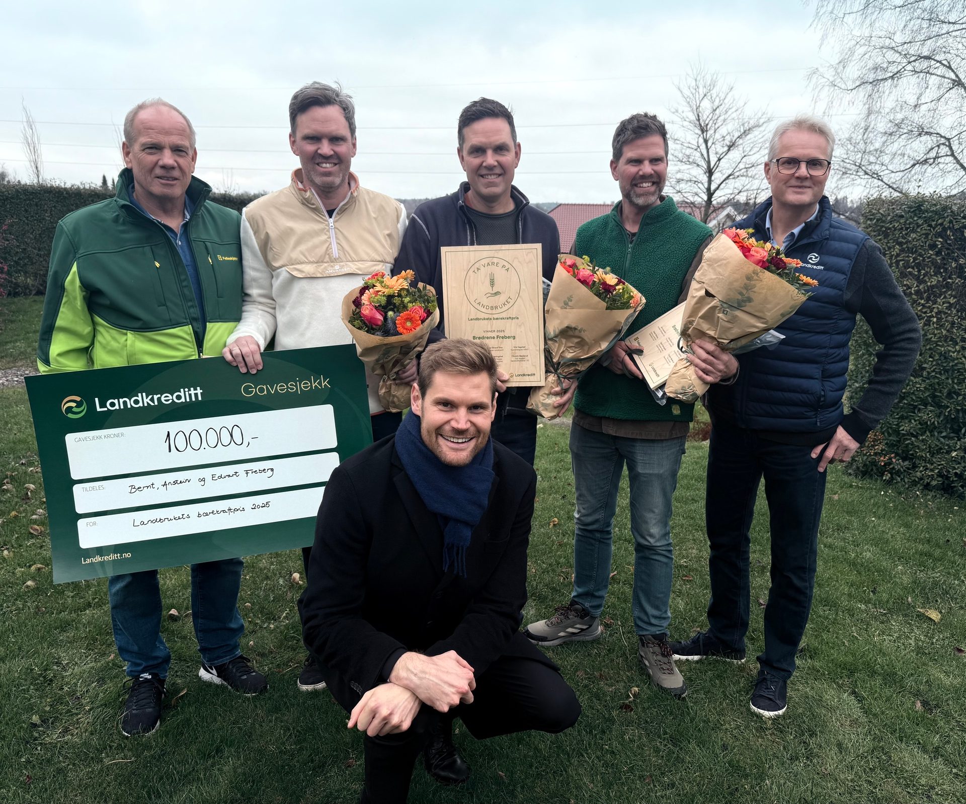 Six men with a 100,000 check and awards for agricultural sustainability.