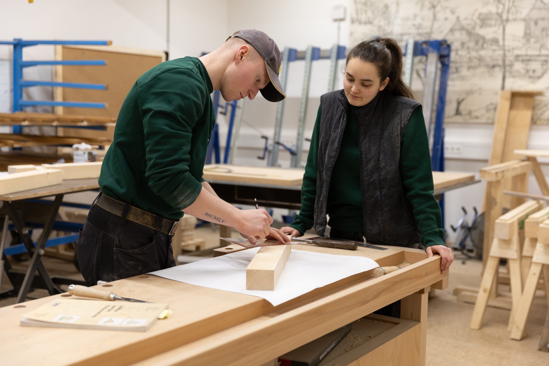 Two young people, a man and a woman, working on a woodworking project, measuring a wooden block.