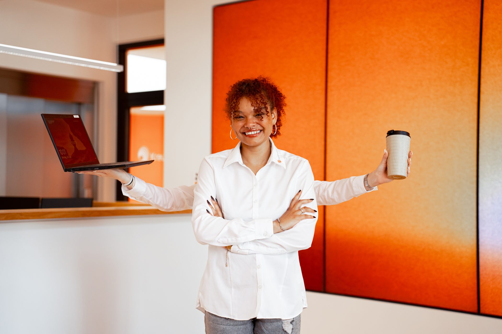 Smiling woman with multi-arms holding a laptop and a coffee cup.
